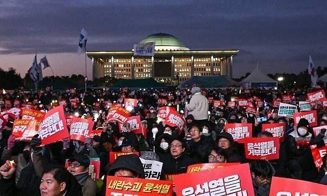 지난 7일 한국 국회의사당 앞에서 시민들이 윤석열 대통령 퇴진을 요구하는 시위에 참여하고 있다. AFP 연합뉴스