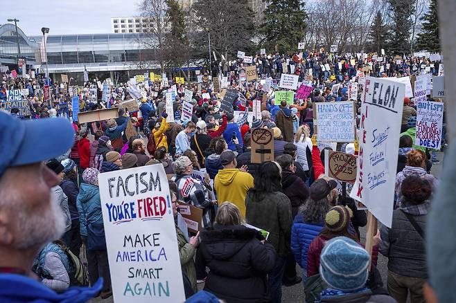 19일(현지시간) 미국 알래스카 앵커리지에서 사람들이 타운 스퀘어 공원에 모여 트럼프 대통령과 그의 정책에 반대하는 시위를 벌이고 있다. [AP]