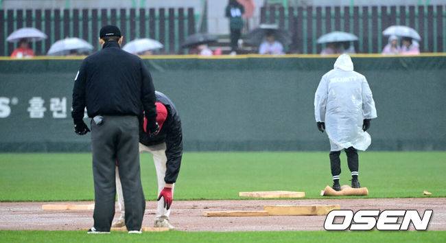 [OSEN=인천, 최규한 기자] 19일 오후 인천 SSG랜더스필드에서 ‘2025 신한 SOL Bank KBO리그’ SSG 랜더스와 LG 트윈스의 경기가 열렸다.이날 홈팀 SSG은 송영진, 방문팀 LG는 손주영을 선발로 내세웠다.4회초 1사 1, 2루 상황 LG 문성주 타석을 앞두고 우천으로 경기가 중단됐다. 젖은 내야를 정비하는 SSG 그라운드 관리 요원들. 2025.04.19 / dreamer@osen.co.kr