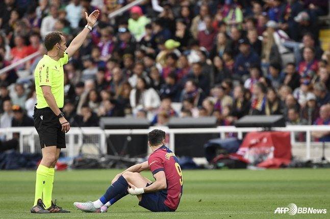 로베르트 레반도프스키(오른쪽)가 허벅지 뒤쪽을 붙잡고 바르셀로나 벤치를 바라보고 있다. /AFPBBNews=뉴스1