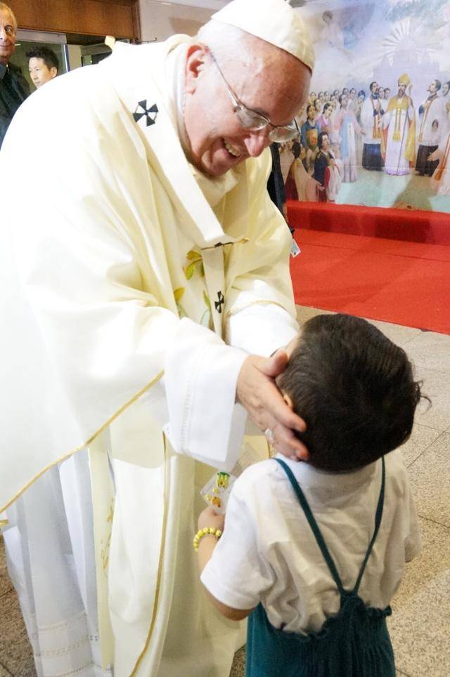 2014년 방한한 프란치스코 교황이 서울 명동성당에서 열린 '평화와 화해를 위한 미사'를 마치고 제의실 앞에서 만난 어린이를 바라보고 있다. 연합뉴스