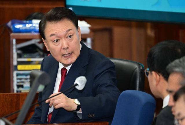 12·3 불법계엄을 선포해 내란 우두머리 혐의로 재판에 넘겨진 윤석열 전 대통령이 21일 오전 서울 서초구 서울중앙지법 417호 법정에 앉아 변호인단과 대화를 하고 있다. 사진공동취재단