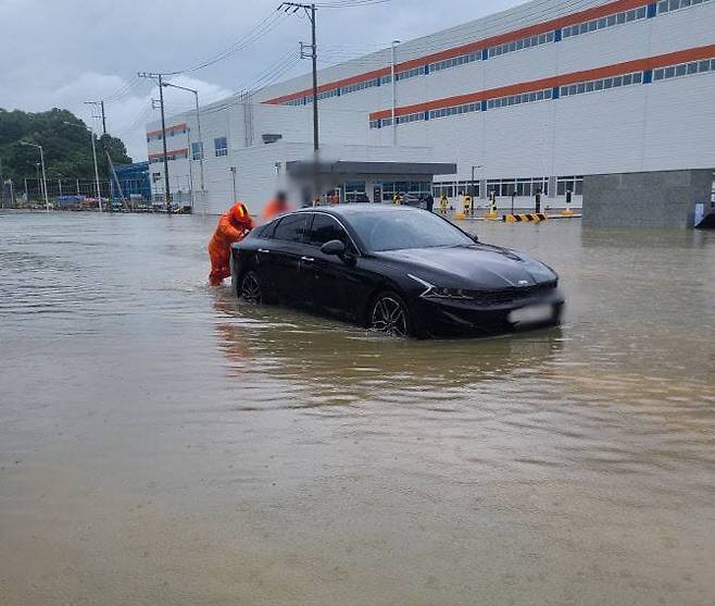 소방대원들이 집중호우로 침수된 차량을 밀어서 이동하는 모습 / 출처=소방청