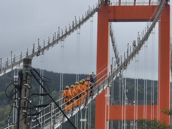 지난 19일 한국 최초 현수교인 경남 남해대교에서 열린 '브리지 클라이밍' 행사 참가자들이 주탑을 향해 걸어 올라가고 있다. 사진 남해군