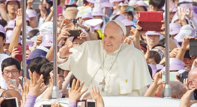 < 한국 신자에 인사 > 프란치스코 교황이 2014년 8월 서울 광화문광장에서 열린 시복식 미사에 앞서 신자들에게 인사하고 있다. /연합뉴스