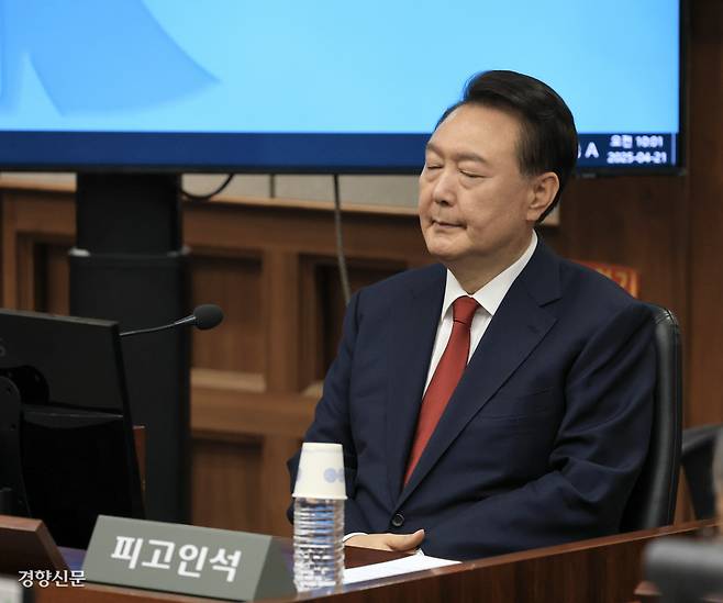 ‘피고인’ 윤석열, 2차 공판서 첫 공개 윤석열 전 대통령이 21일 서울 서초구 서울중앙지법 417호 형사대법정에서 열린 내란 우두머리 혐의 두 번째 형사재판에 출석해 피고인석에 앉아 눈을 감은 채 재판 시작을 기다리고 있다. 이날 ‘피고인 윤석열’의 모습이 언론을 통해 처음 공개됐다. 이준헌 기자