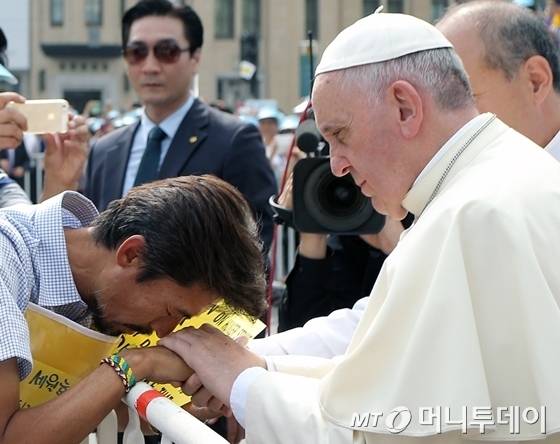 프란치스코 교황(오른쪽)이 8월 16일 서울 광화문 광장에서 열린 시복식 도중 차에서 내려 세월호 유족 김영오씨를 위로하고 있다./사진=머니투데이DB