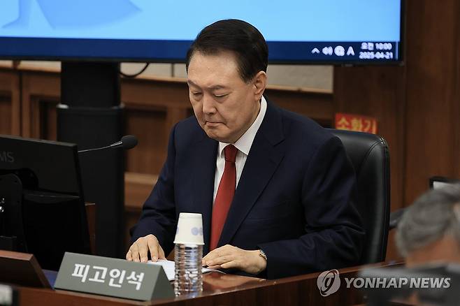 피고인석 앉는 윤석열 전 대통령 (서울=연합뉴스) 윤석열 전 대통령이 21일 서울 서초구 서울중앙지법에서 열린 내란 우두머리 혐의 형사재판 2차 공판에 출석해 있다. 2025.4.21 [사진공동취재단] photo@yna.co.kr