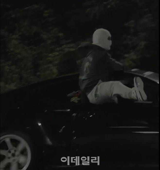 도로교통법 위반 등 혐의로 경찰에 붙잡힘 폭주족들의 운전 장면. 드리프트를 하는 차에 매달려 다리를 내민채 곡예를 부리고 있다.(사진=경기남부경찰청)