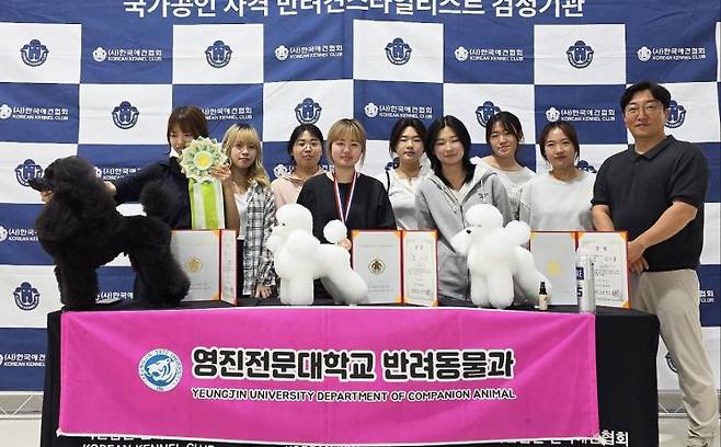 ‘2025 KKC 반려견스타일리스트(미용) 경연대회에 입상한 영진전문대 반려동물과  학생과 대회 참가자들이 한자리에 모여 이종민 지도교수(오른쪽)와 포즈를 취했다.