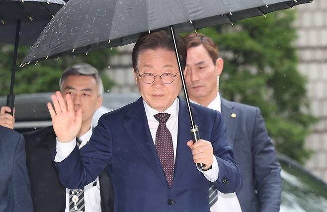 대권 도전에 나선 이재명 더불어민주당 전 대표가 22일 오전 서울 서초구 서울중앙지방법원에서 열린 '대장동 배임 및 성남FC 뇌물' 1심 속행 공판에 출석하며 지지자들에게 손인사를 하고 있다./뉴스1