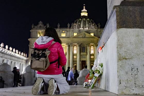 21일(현지시간) 밤 바티칸 성베드로 광장에서 한 관람객이 무릎을 꿇고 프란치스코 교황의 선종을 추모하는 기도를 하고 있다. EPA=연합뉴스