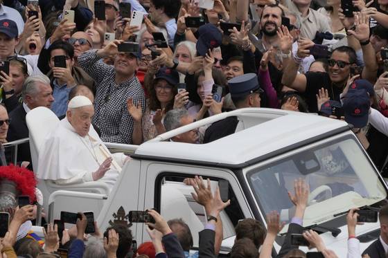 프란치스코 교황이 지난 20일 바티칸 성베드로 광장에서 전용 차량을 타고 군중들을 향해 손을 들어 인사하고 있다. AP=연합뉴스