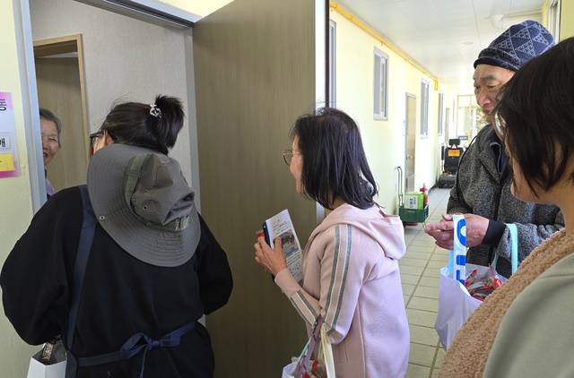 봉사자들이 독신 가구에게 죽을 배달하는 모습.