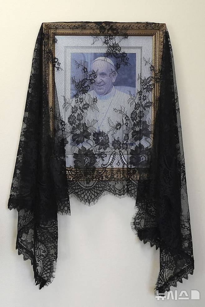 [마이애미=AP/뉴시스] 21일(현지 시간) 미 플로리다주 마이애미의 세인트메리 대성당 사무실 내부에 프란치스코 교황의 사진이 검은 베일에 싸인 채 걸려 있다. 2025.04.22.