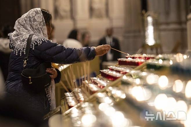 [뉴욕=AP/뉴시스] 고(故) 프란치스코 교황이 선종한 21일(현지 시간) 뉴욕 세인트 패트릭 대성당에서 한 신자가 촛불을 밝히고 있다. 2025.04.22.<font style="vertical-align: inherit;"><font style="vertical-align: inherit;"></font></font>