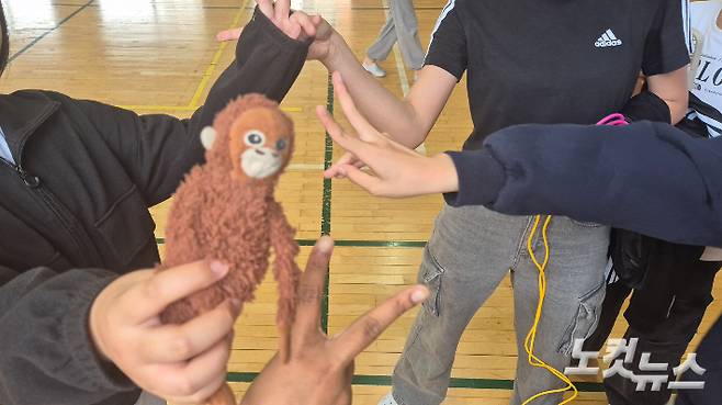 18일 오후, 영암 A 초등학교 학생 파한야(13)와 단짝 친구들이 함께 가지고 노는 원숭이 인형을 보여주며 손가락으로 포즈를 취하고 있다. 한아름 기자