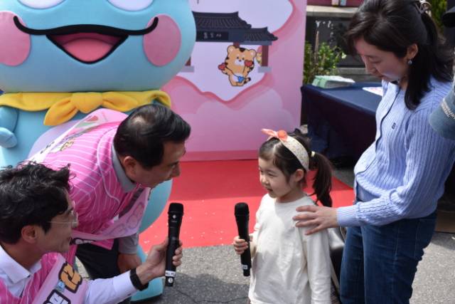 ▲나동연 양산시장이 21일 서울역 광장에서 '2026 양산방문의 해' 기념품을 주며 한 어린이와 기념 촬영을 하고 있다.ⓒ프레시안(석동재)