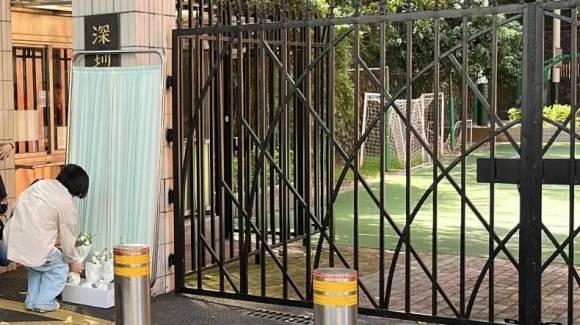 2024년 9월 19일(현지시간) 중국 남부 광둥성 선전에 있는 선전 일본인 학교 앞에서 한 여성이 전날 흉기 습격사건으로 숨진 일본인 초등생을 추모하고자 교문에 꽃다발을 놓고 있다. 로이터 연합뉴스