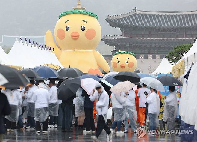 서울 종로구 광화문광장에서 시민들이 우산을 쓰고 이동하고 있다. [연합뉴스 자료사진]
