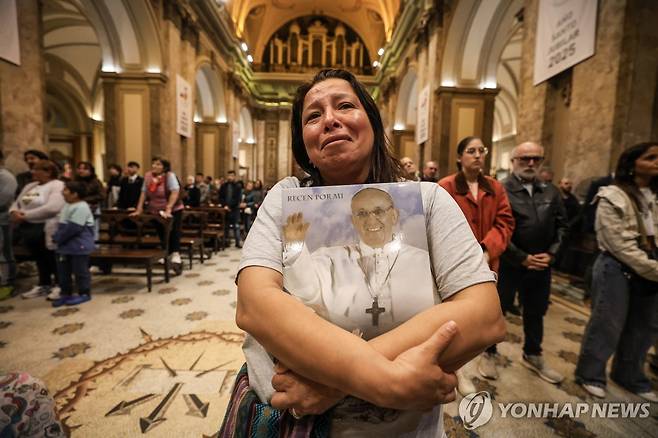 교황의 사진을 끌어안고 울음을 터뜨리는 여성 신자 (부에노스 아이레스 EPA=연합뉴스) 21일(현지시간) 아르헨티나 부에노스 아이레스 대성당에서 프란치스코 교황의 선종을 애도하며 울음을 터뜨리는 여성 신자의 모습. 2025.4.21