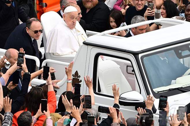 프란치스코 교황이 20일(현지시간) 부활절에 교황전용차를 타고 광장에 모여든 인파 속을 손을 흔들며 지나고 있다. 교황 오른 쪽에는 교황 전속 간호사인 마시밀리아노 스트라페티가 서 있다. 2025.04.20. ⓒ AFP=뉴스1