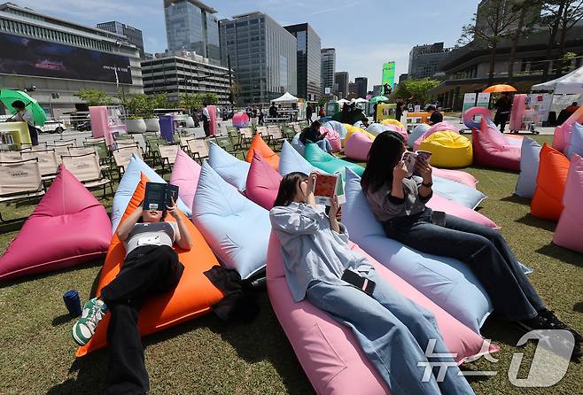 세계 책과 저작권의 날인 23일 서울 종로구 광화문광장에 마련된 '서울야외도서관 광화문 책마당'에서 시민들이 빈백 소파에 기대어 독서 삼매경에 빠져 있다. 서울야외도서관은 금, 토, 일 주 3일제로 운영되며 4~6월, 9~11월 초로 나눠 진행된다. 2025.4.23/뉴스1 ⓒ News1 이동해 기자
