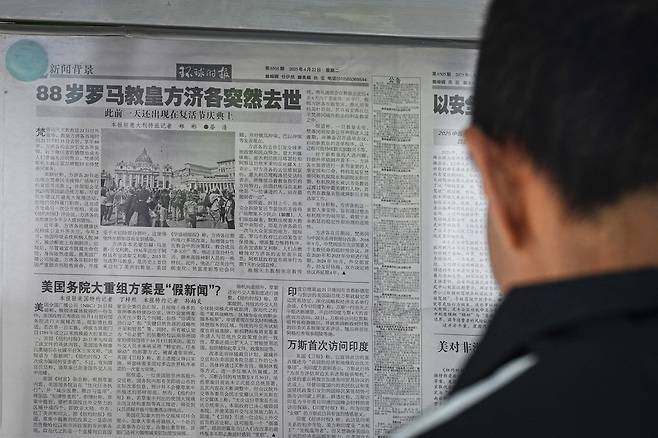 22일 중국 베이징에서 한 시민이 프란치스코 교황 선종 소식이 담긴 신문을 읽고 있다. /AFP연합뉴스