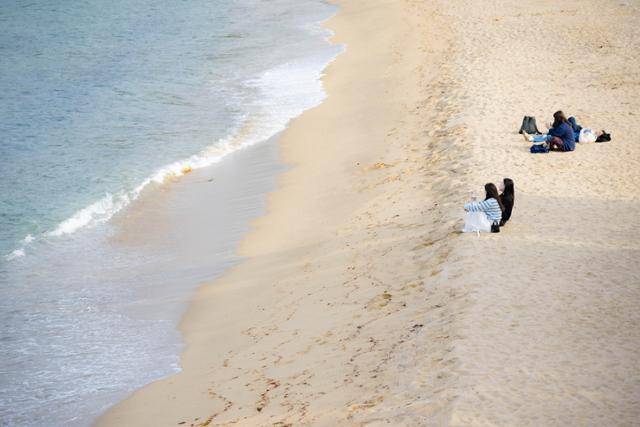 강원 동해시 하평해변 모래사장을 찾은 시민들이 앉아서 바다를 바라보거나 누워 있다.