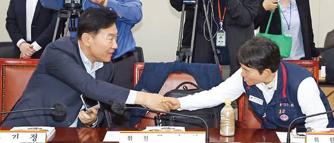 22일 정부세종청사에서 열린 2026년 최저임금위원회 제1차 전원회의에서 사용자위원인 류기정 한국경영자총협회 전무(왼쪽)와 근로자위원인 이미선 민주노총 부위원장이 악수하고 있다. 연합뉴스