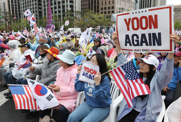 ▲ 4월19일 자유통일당이 서울 종로구 동화면세점 인근에서 개최한 '국민저항권 광화문국민대회'에서 참가자들이 손팻말을 들고 구호를 외치고 있다. ⓒ연합뉴스