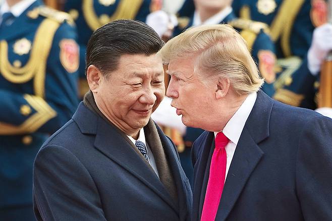 지난 2017년 11월 중국을 방문한 도널드 트럼프 대통령이 베이징 인민대회당에서 시진핑 중국 국가주석과 악수를 하며 대화를 나누는 모습. <AFP 연합뉴스>