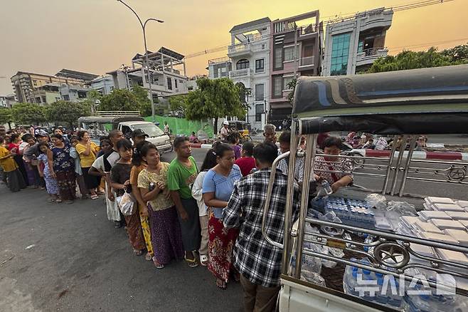 [만달레이=AP/뉴시스] 미얀마 군사정권은 지난달 일어난 7.7 강진으로 인한 구호 작업, 피해 복구를 위한 반군과의 휴전을 30일까지 연장한다고 22일 밝혔다. 사진은 지난 2일 미얀마 만달레이 거리에서 지진 피해 이재민들이 물과 음식을 받고 있는 모습. 2025.04.23.