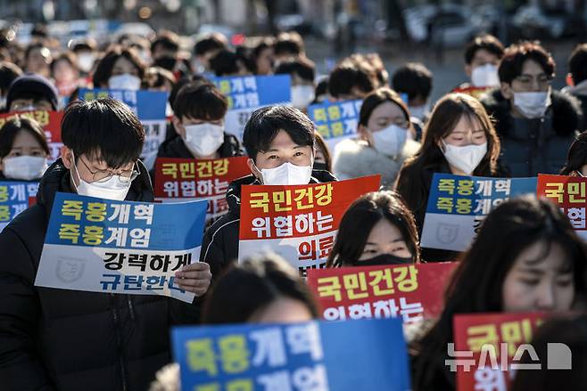 [서울=뉴시스] 정병혁 기자 = 서울 종로구 대학로에서 열린 서울대병원 전공의협의회 비상대책위원회 ‘젊은 의사 의료계엄 규탄 집회’에서 사직 전공의를 비롯한 젊은 의사들이 피켓을 들고 있다. 2024.12.08. jhope@newsis.com
