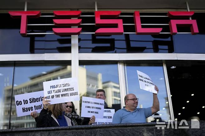 [리스본=AP/뉴시스] 지난달 9일(현지 시간) 포르투갈 리스본에 있는 테슬라 전시관 앞에서 반테슬라 시위를 벌이고 있다. 테슬라는 22일 1분기 매출과 순이익 모두 예상치를 하회했다고 발표했다. 2025.04.23.