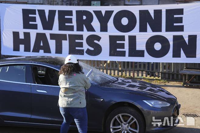 [런던=AP/뉴시스] 지난 10일(현지 시간) 영국 런던에서 한 시위 참가 여성이 폐차 예정이던 테슬라 자동차를 부수고 있다. 이 시위는 일론 머스크 미 테슬라 최고경영자(CEO)에 반대하는 ‘모두가 일론을 증오해' 단체가 주최했다. 2025.04.23.