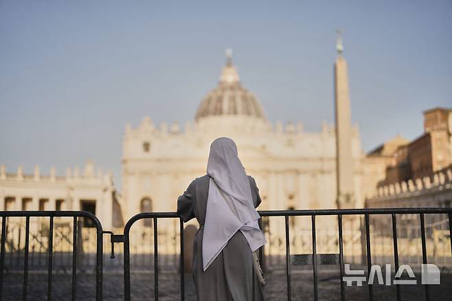 [바티칸시티=AP/뉴시스]한 수녀가 22일 바티칸 성 베드로 광장에 서서 하루 전 선종한 프란치스코 교황을 추모하고 있다. 21일 서거한 프란치스코 교황의 장례식이 26일 오전 10시(한국시간 오후 5시) 치러진다. 바티칸 추기경들은 이 같은 프란치스코 교황의 장례식 일정을 결정하는 한편 교황의 시신이 안치된 관이 교황이 살았던 바티칸 호텔로부터 행렬을 통해 옮겨진 후 23일부터 성베드로 대성당에서 교황의 시신을 공개, 조문을 받기로 결정했다. 2025.04.22.