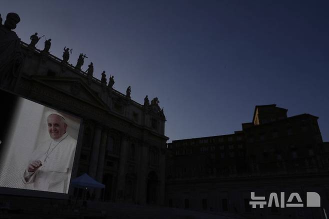 [바티칸=AP/뉴시스] 22일(현지 시간) 바티칸 성 베드로 대성당 옆 대형 스크린에 프란치스코 교황의 모습이 보이고 있다. 바티칸은 프란치스코 교황의 장례식을 오는 26일 오전 10시(한국 시간 오후 5시)에 거행하기로 하고, 교황의 시신이 안치된 관이 성 베드로 대성당으로 옮겨지는 23일부터 일반 신자들의 공개 조문을 받기로 했다. 2025.04.23.