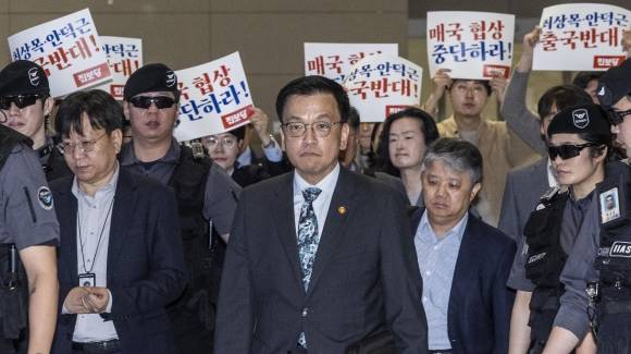 최상목 부총리 ‘한미 2+2 협의’ 참석 위해 출국 - 최상목(가운데) 부총리 겸 기획재정부 장관이 23~25일(현지시간) 미국 워싱턴 DC에서 열리는 한미 ‘2+2 통상협의’, 주요 20개국(G20) 재무장관회의 및 국제통화금융위원회(IMFC) 등에 참석하기 위해 22일(한국시간) 인천국제공항 출국장에서 이동하고 있다. 최 부총리 뒤로 진보당이 대미 무역 협상 중단을 요구하는 피켓 시위를 벌이고 있다. 연합뉴스