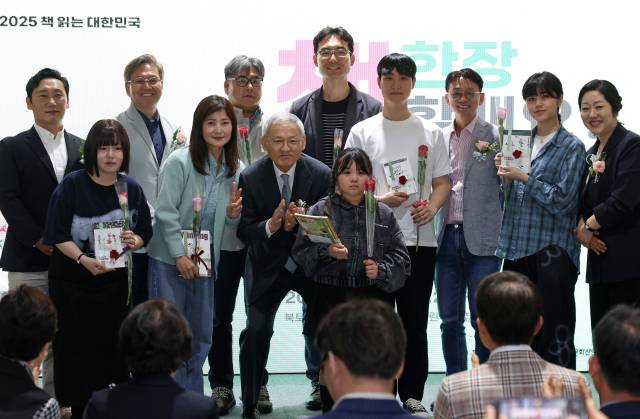 유인촌 문화체육관광부 장관이 20일 서울 종로구 대한민국역사박물관 1층 로비에서 열린 ‘2025 세계 책의 날 기념행사’에 참석해 시민들에게 책과 장미를 선물하고 기념촬영을 하고 있다. 사진 제공=문체부