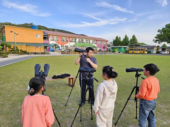 2024년 4월19일, 서충현 선생님이 동복초등학교 운동장에서 1~2학년 학생들에게 쌍안경 사용법을 가르치고 있다. ⓒ이정호