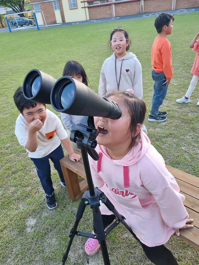 같은 날, 쌍안경을 직접 조준해서 낮달을 관측한 김하율 학생이 활짝 웃고 있다. ⓒ서충현
