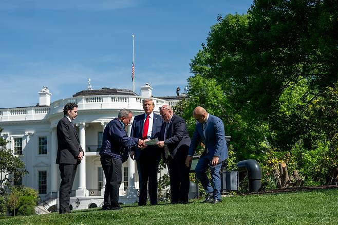 도널드 트럼프 미국 대통령이 23일 관계자들과 함께 백악관 내에 대형 깃대를 세울 위치를 둘러보고 있다. /백악관