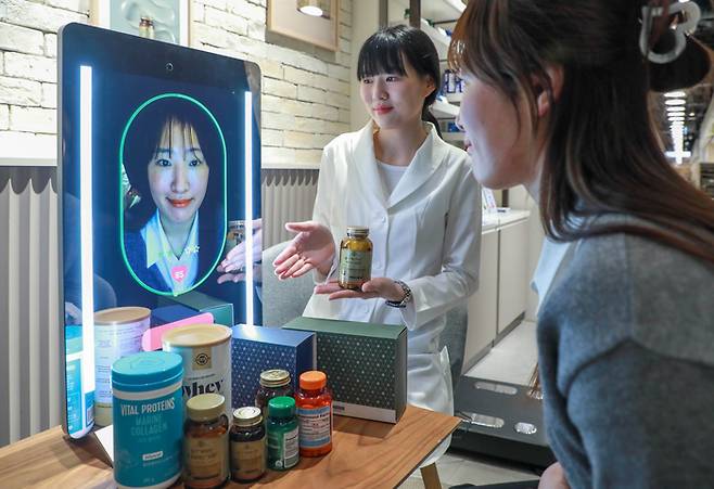 고객이 현대백화점 목동점 네슬레 헬스사이언스 매장에서 AI 기반 헬스케어 전문 기기 '아누라 매직미러(Anura Magic Mirror)'를 체험하고 있다.