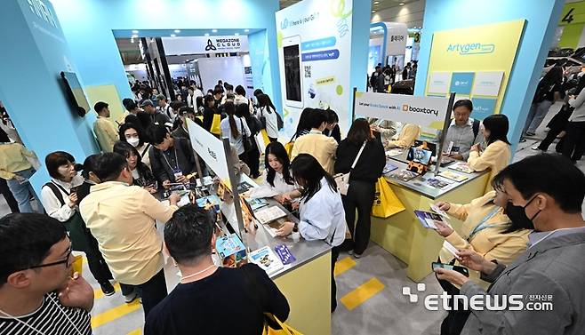 국내 최고 정보통신기술(ICT) 축제 월드IT쇼(WIS) 2025가 24일 서울 강남구 코엑스에서 열렸다. 참관객이 아티젠스페이스의 AR북을 살펴보고 있다.  이동근기자 foto@etnews.com