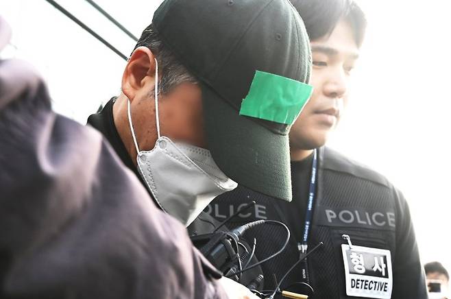 부모와 처자식 등 일가족 5명을 살해한 혐의로 구속된 가장 A씨가 24일 경기 용인동부경찰서 유치장을 나와 검찰로 송치되고 있다. A씨는 지난 14일 경기 용인시 수지구 아파트 자택에서 80대 부모와 50대 배우자, 10대와 20대 자녀 등 일가족 5명을 수면제를 먹인 뒤 살해한 혐의를 받고 있다.  뉴시스