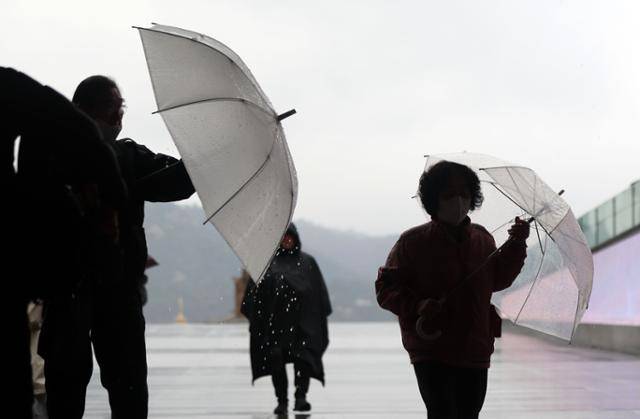 수도권에 봄비가 내린 14일 서울 종로구 광화문광장에서 우산을 쓴 시민들이 길을 걷고 있다. 뉴시스