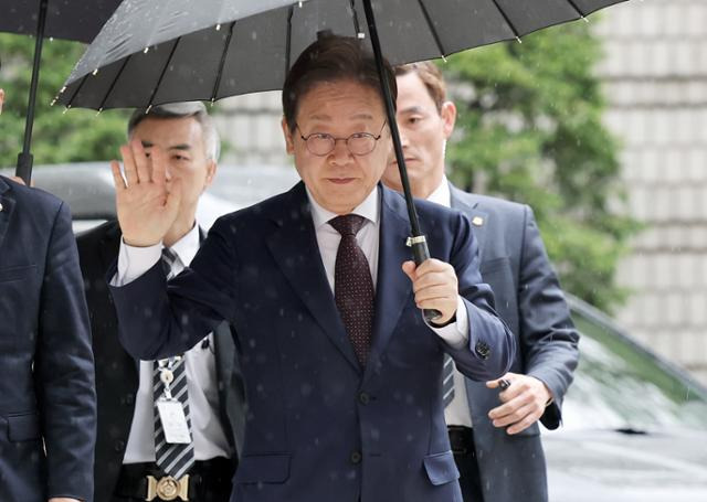 이재명(오른쪽 두 번째) 전 더불어민주당 대표가 22일 서울 서초구 서울중앙지법에서 열린 대장동 배임 및 성남FC 뇌물 사건 1심 공판에 출석하며 지지자들에게 손인사를 하고 있다. 뉴스1