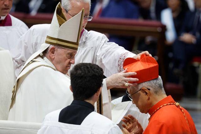 유흥식 라자로 추기경이 2022년 바티칸 성베드로 대성전에서 열린 추기경 서임식에서 프란치스코 교황으로부터 추기경의 상징인 빨간색 사제 각모(비레타)를 받고 있다. 바티칸=EPA 연합뉴스