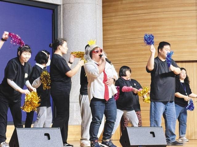경기도지적발달장애인복지협회 파주시지부에서 온 발달장애인들이 23일 파주 순복음평화교회에서 열린 어울림마당 무대에 올라 노래에 맞춰 응원 도구를 흔들고 있다.